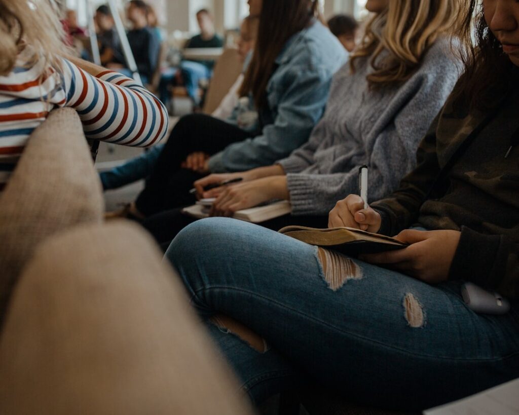 Student writes in a notebook during a group study session.